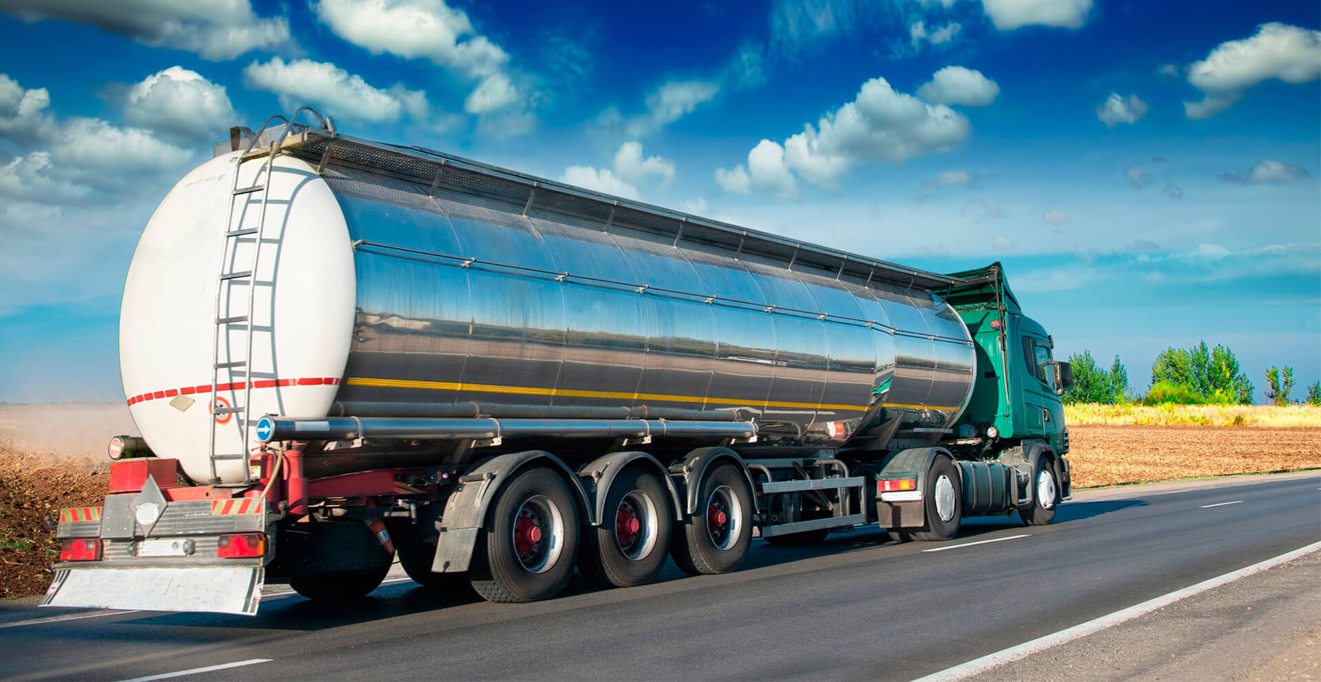 Sølvfarget tankbil fra Kvasnes Logistikk på veien for sikker og skreddersydd tanktransport av flytende gods, kjemikalier og næringsmidler.